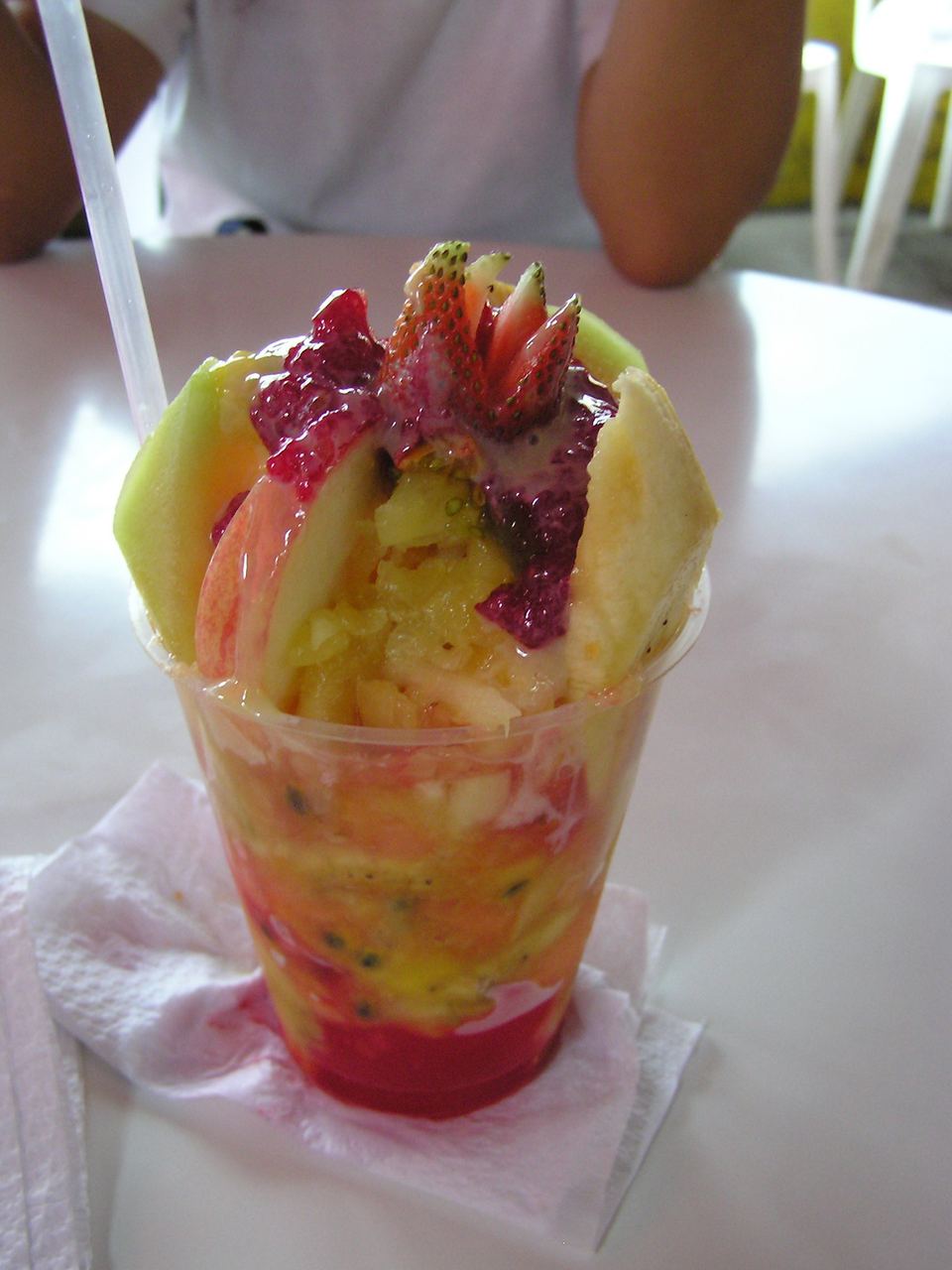 Vaso de cholado con hielo raspado, frutas picadas y melao