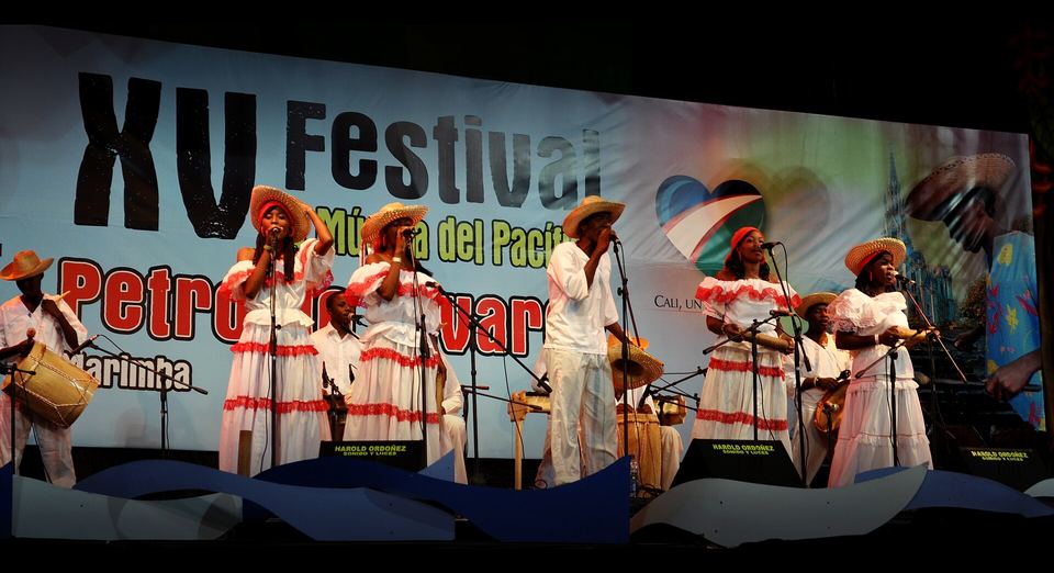 Cantadoras con vestidos blancos y músicos con tambores en la tarima del XV Festival Petronio Álvarez